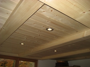 Poutraison visible en bois avec faux plancher en lambris traité naturel ou blanc
